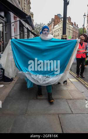 London, Großbritannien. August 2021. Demonstranten, die als „Welle“ verkleidet sind, treten während des Protestes auf dem Trafalgar Square auf, wobei einige Mitglieder ihre Arme unter Transportern verriegeln, um Straßen im Westen und in der Stadt zu blockieren. (Bild: © Dave Rushen/SOPA Images via ZUMA Press Wire) Stockfoto