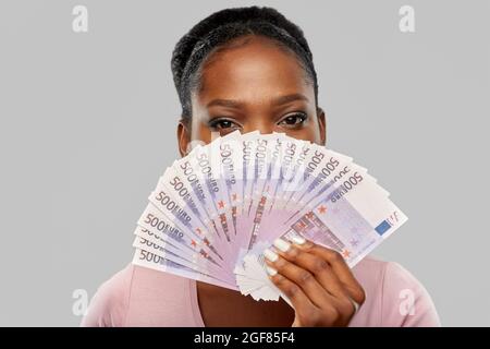 afroamerikanische Frau, die sich hinter Euro-Geld versteckt Stockfoto
