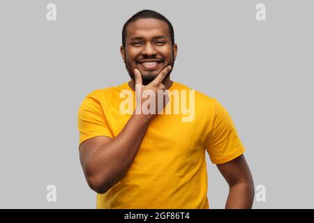 Lächelnder afroamerikanischer Mann in gelbem T-Shirt Stockfoto