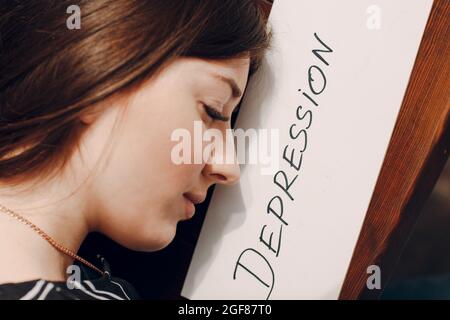 Frau Profil Porträt mit weißem Blatt Papier beschriftet Wort Depression. Konzept der versteckten Depression. Stockfoto