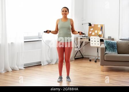 afrikanische Frau, die zu Hause mit Springseil trainiert Stockfoto
