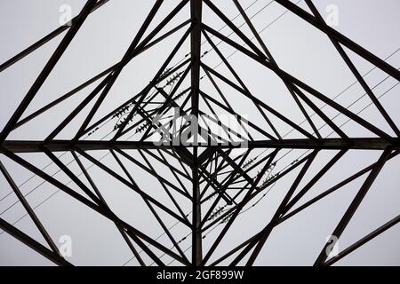 Direkt Unter Dem Strompylon Gegen Den Himmel. Abstraktes Muster aus der unteren Ansicht des Hochspannungspols Stockfoto