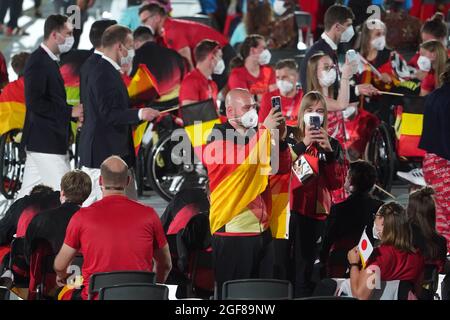 Tokio, Japan. August 2021. Paralympics: Eröffnungsfeier im Olympiastadion. Die Athleten des Teams Deutschland kamen bei der Eröffnungsfeier an den ihnen zugewiesenen Plätzen an. Dennis Nohl, Nationaltrainer der Rollstuhlbasketballmannschaft der Frauen, und Fahnenträger Mareike Miller, ein Rollstuhlbasketballspieler, fotografieren mit ihren Mobiltelefonen. Quelle: Karl-Josef Hildenbrand/dpa/Alamy Live News Stockfoto