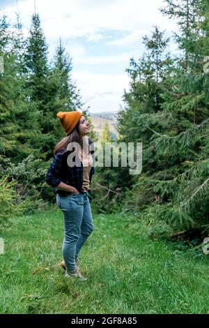 Schöne Frau, die in den Bergen wandert. Natur Freizeitaktivitäten im Wald. Kaukasische Frau Porträt Hipster in Hut auf Berglandschaft. Stockfoto