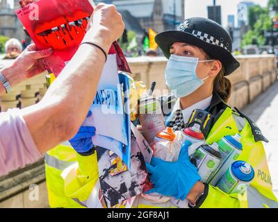 London, Großbritannien. August 2021. Anti-Barclays und Anti-Öl-Worte werden auf den Bürgersteig vor den Büros des HMRC gesprüht die Polizei sammelt die Spraydosen und warnen einige der Demonstranten - XR Cymru protestiert vor HM Revenue and Customs in Whitehall über die Regierungen, die mit der fossilen Energiewirtschaft zu tun haben, und auch Barclays Aufzeichnungen darüber Finanzierung - Extinction Rebellion startet zwei Wochen lang unter dem Namen Impossible Rebellion in London. Kredit: Guy Bell/Alamy Live Nachrichten Stockfoto