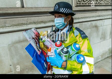 London, Großbritannien. August 2021. Anti-Barclays und Anti-Öl-Worte werden auf den Bürgersteig vor den Büros des HMRC gesprüht die Polizei sammelt die Spraydosen und warnen einige der Demonstranten - XR Cymru protestiert vor HM Revenue and Customs in Whitehall über die Regierungen, die mit der fossilen Energiewirtschaft zu tun haben, und auch Barclays Aufzeichnungen darüber Finanzierung - Extinction Rebellion startet zwei Wochen lang unter dem Namen Impossible Rebellion in London. Kredit: Guy Bell/Alamy Live Nachrichten Stockfoto