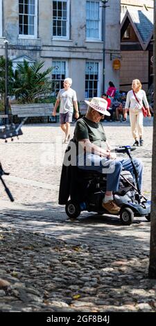 Truro, Großbritannien. August 2021. Die Menschen nutzen den herrlichen Sonnenschein in Truro, Cornwall. Ein Mann in einem Motorroller saß vor der atemberaubenden Kathedrale und hörte Musik. Die Prognose ist für 19C, sonnige Intervalle und eine leichte Brise. Kredit: Keith Larby/Alamy Live Nachrichten Stockfoto