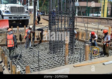 MANZANILLO, MEXIKO - 28. Feb 2015: Gruppe mexikanischer Bauarbeiter während des Gießens von Beton für ein Brückenfundament mit einer Stahlreinfork Stockfoto