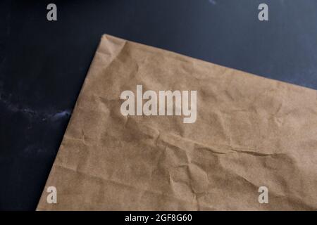 Draufsicht auf einen Papierkraftsack auf schwarzem Hintergrund Stockfoto