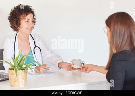 Ärztin verschreibt in ihrem Büro einige Pillen Stockfoto