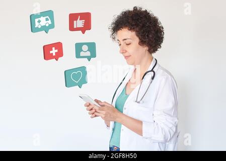 Ärztin verwendet ihr Smartphone mit 3d-Gesundheits-Symbolen Stockfoto