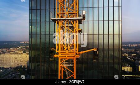 Luftaufnahme des im Bau befindlichen Business-Wolkenkratzers. Bau eines modernen, hohen Glasgebäudes mit mehrstöckigen Apartments. Stockfoto