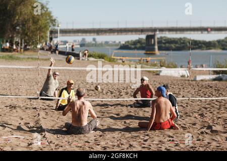 Moskau, Russland - 14. Juli 2020: Sitzbehinderte amputierte Volleyballspieler spielen am Strand Stockfoto