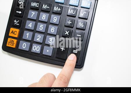 Nahaufnahme eines Mannes, der Berechnungen auf einem Rechner macht. Stockfoto