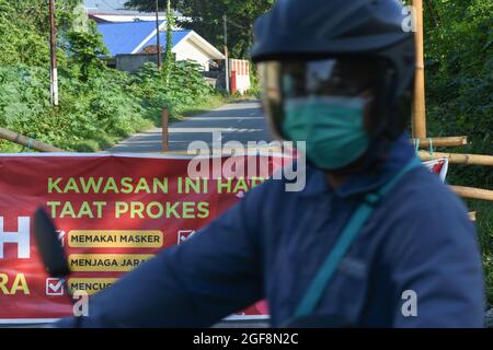 Palu, Indonesien. August 2021. Ein Porträt des Bombenentsorgungsteams (Gegana) der Central Sulawesi Police beim Sprühen von Desinfektionsmittel in einem Wohngebiet in Palu City, Zentral-Sulawesi. Diese Bemühungen werden unternommen, um die Kette der Ausbreitung von Covid-19 zu durchbrechen, die in der lokalen Region zunehmend endemisch ist. (Foto: Adi Pranata/Pacific Press/Sipa USA) Quelle: SIPA USA/Alamy Live News Stockfoto