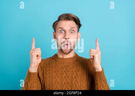 Foto von schockiert erstaunt jungen Mann zeigen Finger auf leeren Raum isoliert auf pastellblauen Hintergrund Stockfoto