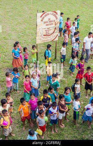 SANTA MARIA DE ANGOTEROS, PERU - 15. JULI 2015: Kinder des Dorfes Santa Maria de Angoteros beobachten ein Boot, das auf einem Fluss Napo ankommt. Stockfoto