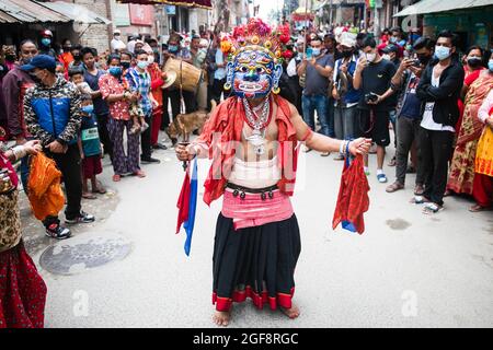 Ein als Gottheit verkleideter Anhänger nimmt an einer traditionellen Prozession während des Khadga Jatra, dem Schwertfest in Hadigaun, Teil. Die maskierten Tänzer der Newar Community, bekannt als Ajimas, feiern das Payo Jatra Festival. Stockfoto