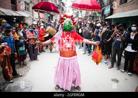 Ein als Gottheit verkleideter Anhänger nimmt an einer traditionellen Prozession während des Khadga Jatra, dem Schwertfest in Hadigaun, Teil. Die maskierten Tänzer der Newar Community, bekannt als Ajimas, feiern das Payo Jatra Festival. Stockfoto