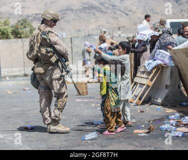 Kabul, Afghanistan. August 2021. Eine US-Marine mit dem Special Purpose Marine Air-Ground Task Force/Crisis Response Team wird während der Operation Allies Refuge am 21. August 2021 in Kabul, Afghanistan, von spielenden Kindern auf die Evakuierung am Hamid Karzai International Airport mit Wasser besprüht. Quelle: Planetpix/Alamy Live News Stockfoto