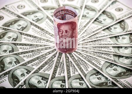 Chinesisches Geld, Renminbi, 100 Yuan Banknote, in die Enge von vielen hundert Dollar-Scheinen gedrängt Stockfoto