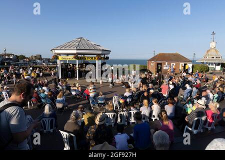 Menschen, die einer Ukulele-Band zuhören, die während der Broadstairs Folk Week, August 2021, am Bandstand auftrat Stockfoto
