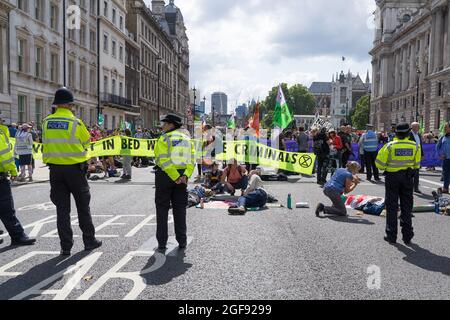 Extinction Rebellion protestiert gegen Whitehall aus Protest gegen HMRC und Barclays. Demonstranten mit in Röhren verschlossenen Armen, umgeben von der Polizei. Stockfoto