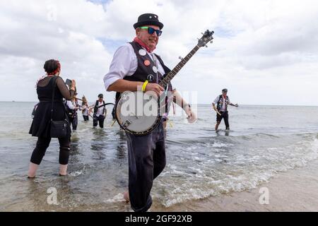 Eine Gruppe von morris-Tänzern von Dead Horse Morris paddelt in der Viking Bay, nachdem sie bei der Broadstairs Folk Week, August 2021, aufgetreten ist Stockfoto