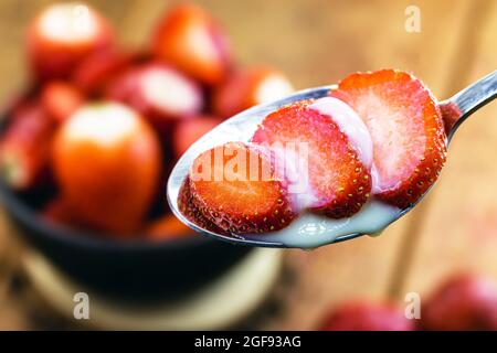 Löffel mit geschnittener ​​strawberries und Kondensmilch, schnelles Dessert Stockfoto