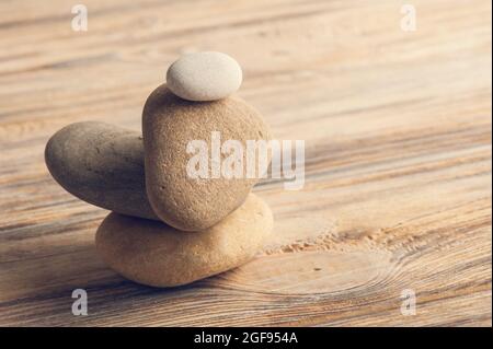 Schöne Zen-Komposition mit Steinen auf schäbigen Holzhintergrund. Getönter Jahrgang Stockfoto