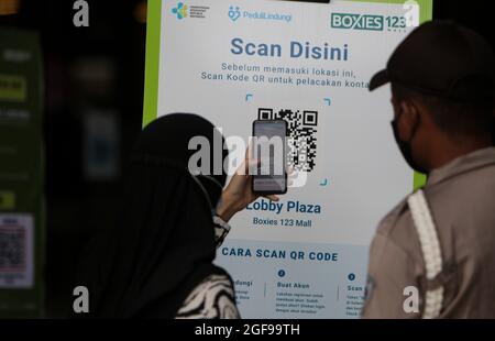 Bogor, Indonesien. August 2021. Ein Beamter Mall Check für QR-Codes identifiziert COVID-19 Impfpass für einen Besucher in einem Einkaufszentrum, nachdem die Ebene der öffentlichen Aktivitäten Einschränkungen wurden von 4 auf 3 reduziert in Bogor, West Java, Indonesien am 24. August 2021. (Foto von Adriana Adie/INA Photo Agency/Sipa USA) Quelle: SIPA USA/Alamy Live News Stockfoto