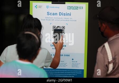 Bogor, Indonesien. August 2021. Eine Frau scannt den QR-Code, um ein Einkaufszentrum zu betreten, nachdem die Anzahl der Beschränkungen für öffentliche Aktivitäten am 24. August 2021 in Bogor, West-Java, Indonesien, von 4 auf 3 reduziert wurde. (Foto von Adriana Adie/INA Photo Agency/Sipa USA) Quelle: SIPA USA/Alamy Live News Stockfoto