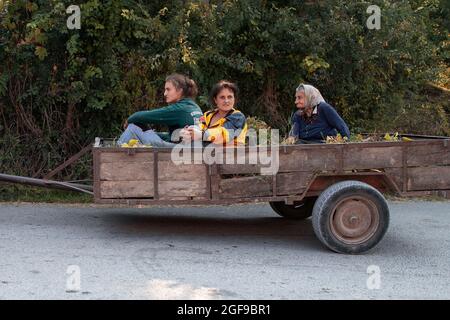 Village Vrmdža, Serbien, 17. Aug 2021: Drei Generationen von Dorfbewohnern, die in einem Traktoranhänger fahren Stockfoto