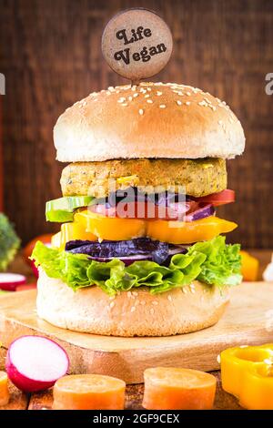 Veganer Burger, fleischloses Gemüse-Sandwich, veganes Essen mit Gemüse im Hintergrund Stockfoto