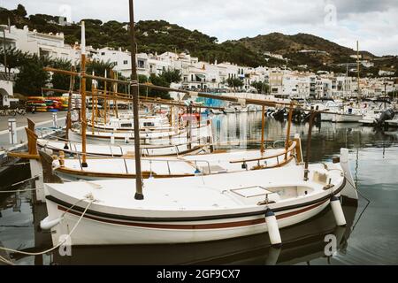 Blick auf die kleine spanische Stadt Port de la Selva Hafen an der Costa Brava in Katalonien, mit kleinen weißen Fischerbooten an einem bewölkten Sommertag während zu Stockfoto