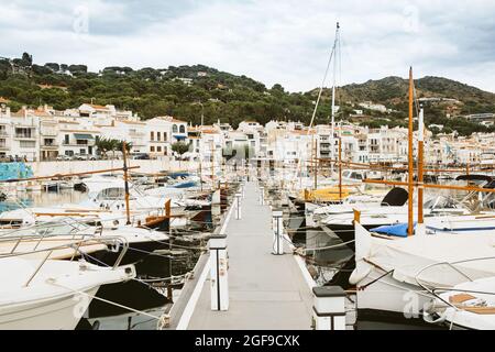 Blick auf die kleine spanische Stadt Port de la Selva Hafen an der Costa Brava in Katalonien, mit kleinen weißen Fischerbooten an einem bewölkten Sommertag während zu Stockfoto