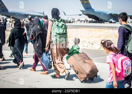 Ein Kind schaut auf das Flugzeug, während es während einer Evakuierung am Hamid Karzai International Airport, Kabul, Afghanistan, im August 24, auf seinen Flug zuläuft. US-Dienstmitglieder unterstützen das Außenministerium bei einer geordneten Abseichung von designiertem Personal in Afghanistan. (USA Marine Corps Foto von Sgt. Samuel Ruiz). Stockfoto