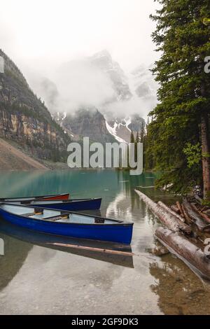 Blaue Kanus am Moraine Lake, Banff National Park, Alberta, Kanada, an einem regnerischen Sommertag. Stockfoto