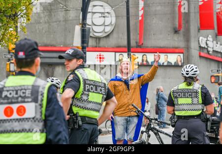 Mann mit Kronenangriffen bei der Polizei während des Aussterbens Rebellions-Demonstranten besetzen Kreuzung, Vancouver, British Columbia, Kanada Stockfoto