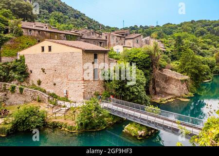 Ein Blick auf das kleine Dorf Stifone am Fluss Nera. Umbrien, Terni, Italien. Die Wände aus Steinen und Ziegeln. Die Brücke über den Fluss mit cle Stockfoto