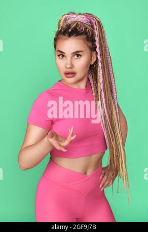 Junge Frau mit Dreadlocks in rosa Sportkleidung Stockfoto