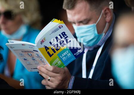 Die Leute lasen das Programm während der Eröffnung des jährlichen Medef-Sommertreffens La Ref am 24. August 2021 auf der Rennstrecke Longchamp in Paris. Foto von Raphael Lafargue/ABACAPRESS.COM Stockfoto