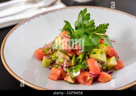 Türkischer Coban (Choban)-Salat oder Shepherds-Salat auf schwarzem Tisch. Stockfoto