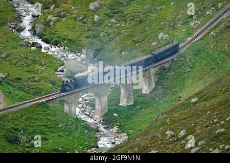 Furka-Dampfzug durch die Berglandschaften der Zentralalpen auf der historischen Glacier Express-Route. Furkapass, Schweiz - August 2021 Stockfoto