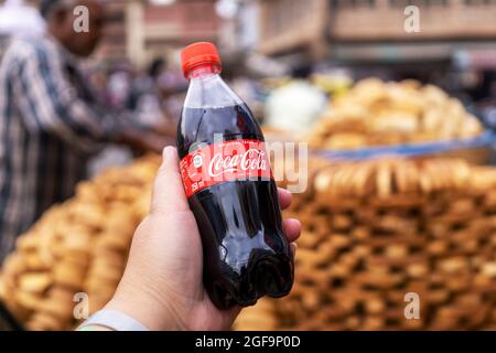 Mandawa, Indien - 28. Februar 2018: Handhaltende Flasche Mini Coca-Cola. Stockfoto