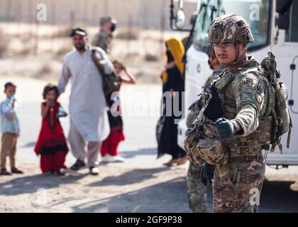 Flugplatz Ali Al Salem, Kuwait. August 2021. Eine Militärpolizei der US-Luftwaffe mit der 16. Militärpolizeibrigade leitet afghanische Flüchtlinge während der Operation Allies Refuge bei der Ankunft am Ali Al Salem Airbase am 23. August 2021 in Ali Al Salem, Kuwait. Quelle: Planetpix/Alamy Live News Stockfoto