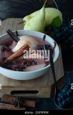 Birnenpunsch mit Gewürzen und Trauben in Rotwein Stockfoto