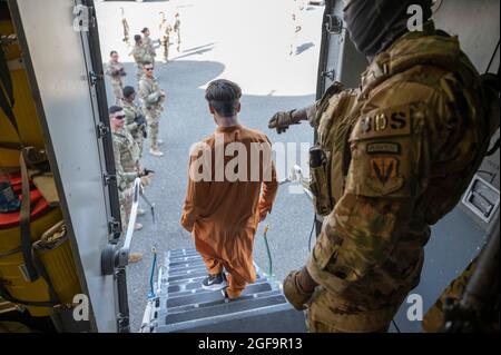 Flugplatz Ali Al Salem, Kuwait. August 2021. Ein US-Luftwaffenflieger lenkt afghanische Flüchtlinge beim Aussteigen aus einem C-17 Globemaster III-Flugzeug während der Operation Allies Refuge bei der Ankunft auf dem Ali Al Salem Airbase am 23. August 2021 in Ali Al Salem, Kuwait. Quelle: Planetpix/Alamy Live News Stockfoto