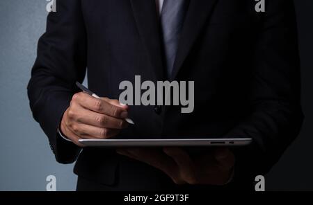 Geschäftliche Hand mit einem Stift, um Notizen auf einem digitalen Aufnahme Tablet-Bildschirm Geschäftsinformationen Arbeitsplan zu machen Stockfoto