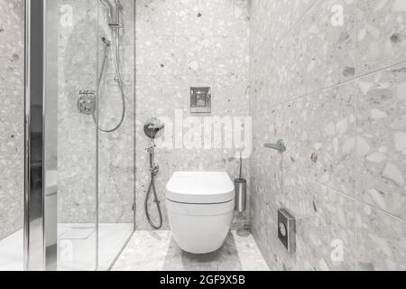 Modernes, minimalistisches Badezimmer mit Chrom-Accessoires im Badezimmer und grauen Fliesen Stockfoto